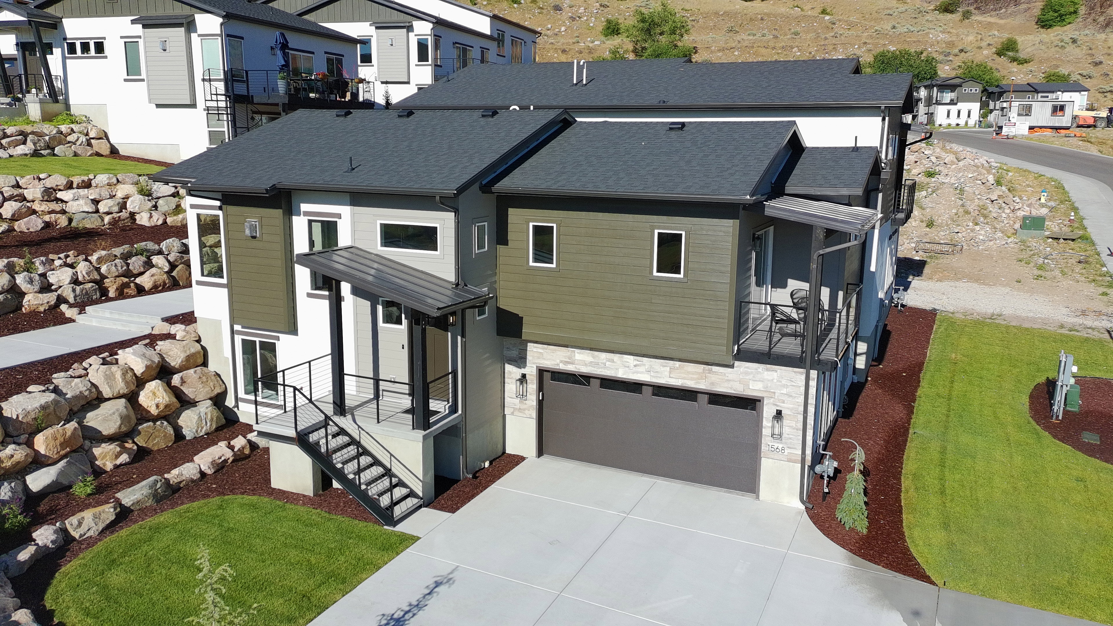 Contemporary multi-level residence featuring a dark gray roofline and a mix of siding materials