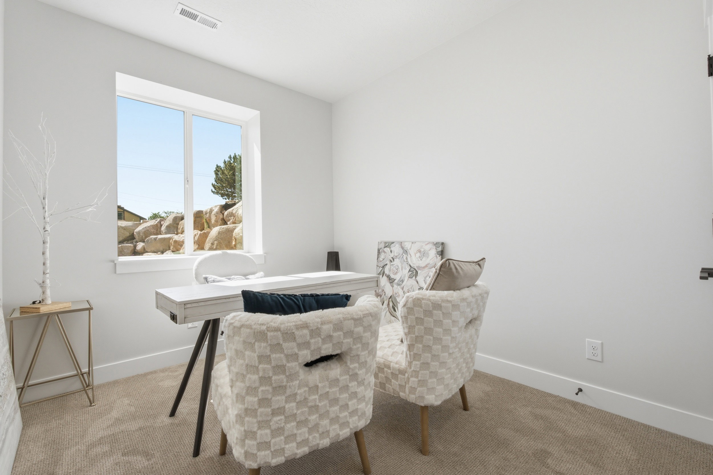 Carpeted room with a large window, white walls, white trim, and a white ceiling
