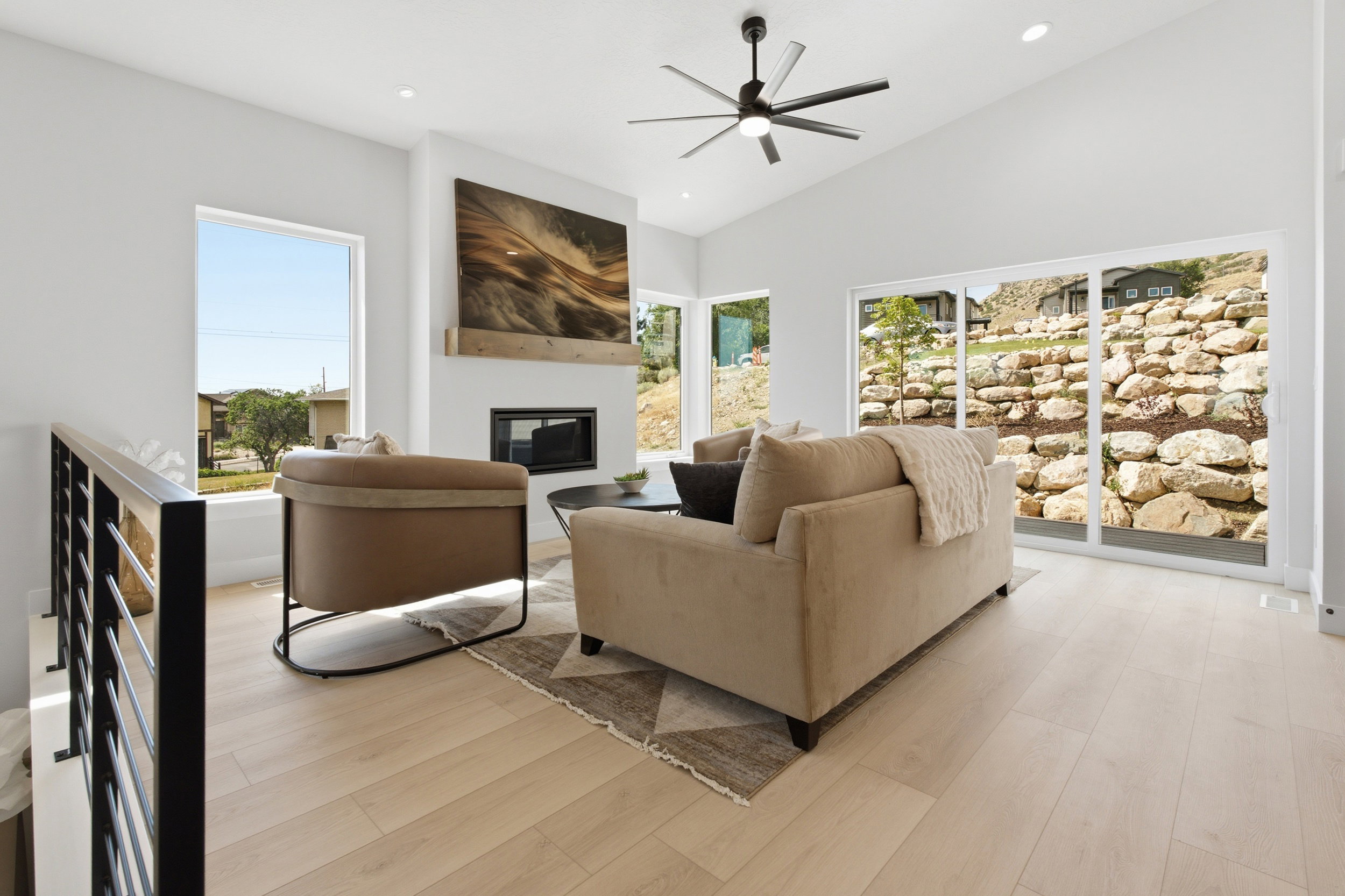 Bright living space featuring a vaulted ceiling and a modern ceiling fan