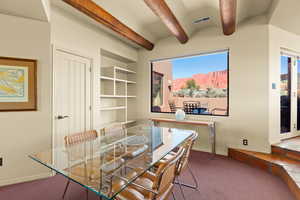 Dining area with beamed ceiling, dark colored carpet, and a mountain view