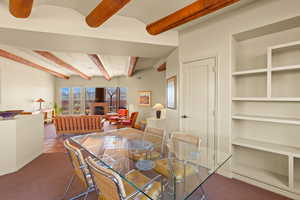 Dining space featuring beam ceiling, built in features, and carpet floors