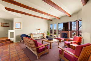 Carpeted living room featuring beam ceiling, tile patterned flooring, and recessed lighting