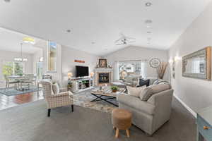 Living area featuring a glass covered fireplace and dark colored carpet