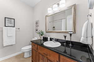 Full bath with vanity, curtained shower, and light tile patterned flooring