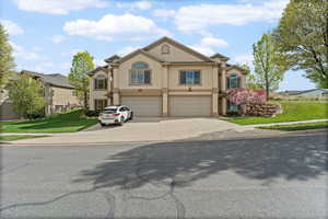 View of front of home featuring stucco siding, a garage, concrete driveway, and a front lawn