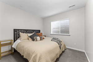 Bedroom with dark colored carpet and baseboards