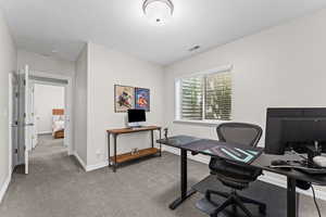 Carpeted office space featuring a textured ceiling