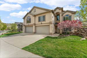 Mediterranean / spanish house featuring stucco siding, an attached garage, driveway, and a front yard