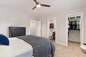 Bedroom with a spacious closet, light carpet, lofted ceiling, ceiling fan, and recessed lighting