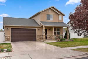 Craftsman inspired home with a shingled roof, stone siding, a porch, an attached garage, and concrete driveway