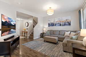 Living area featuring stairs and dark wood finished floors
