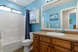 Full bath with vanity, shower / tub combo, and dark tile patterned floors