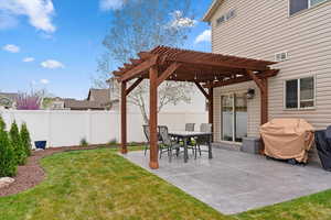 Fenced backyard with a patio area, a pergola, and outdoor dining space