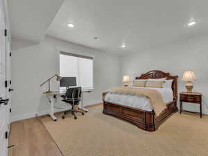 Bedroom featuring an office area, light wood finished floors, and recessed lighting