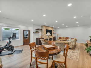 Dining room featuring light wood finished floors, a fireplace, and recessed lighting