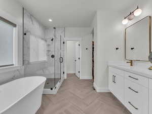 Bathroom featuring vanity, a marble finish shower, a soaking tub, a walk in closet, and recessed lighting