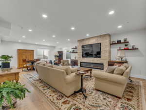 Living area featuring recessed lighting, a fireplace, and light wood-style floors