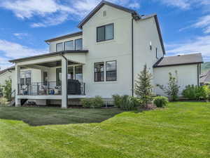 Rear view of house with a yard and stucco siding