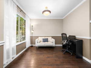 Home office featuring dark wood-type flooring and ornamental molding