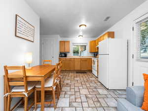 Kitchen featuring white appliances, light countertops, and wood finish cabinetry
