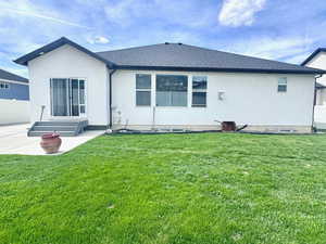 Rear view of property featuring a patio area, a shingled roof, and stucco siding