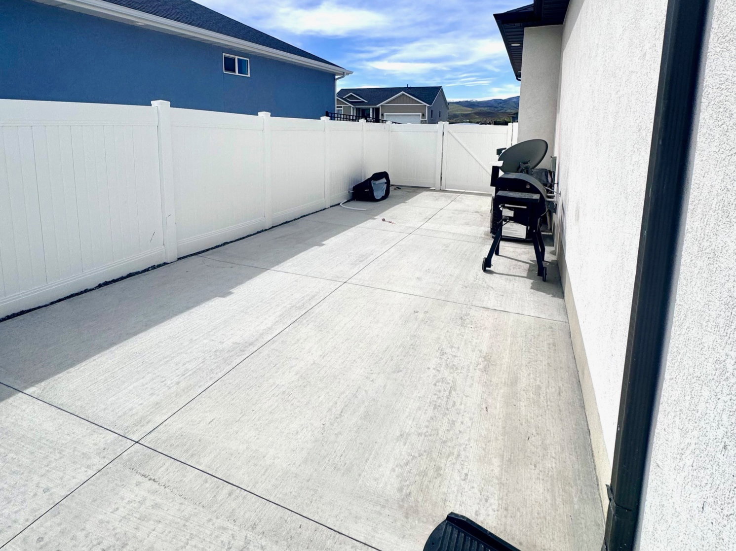 Fenced backyard featuring a grill