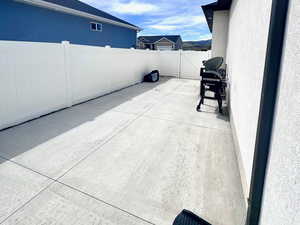 Fenced backyard featuring a grill