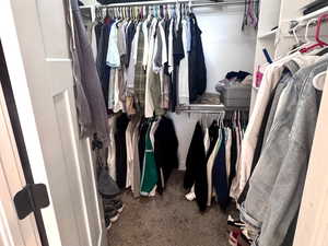 Walk in closet with dark carpet