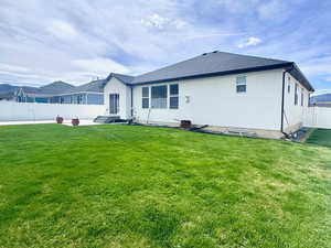 View of property exterior with a fenced backyard, stucco siding, and roof with shingles