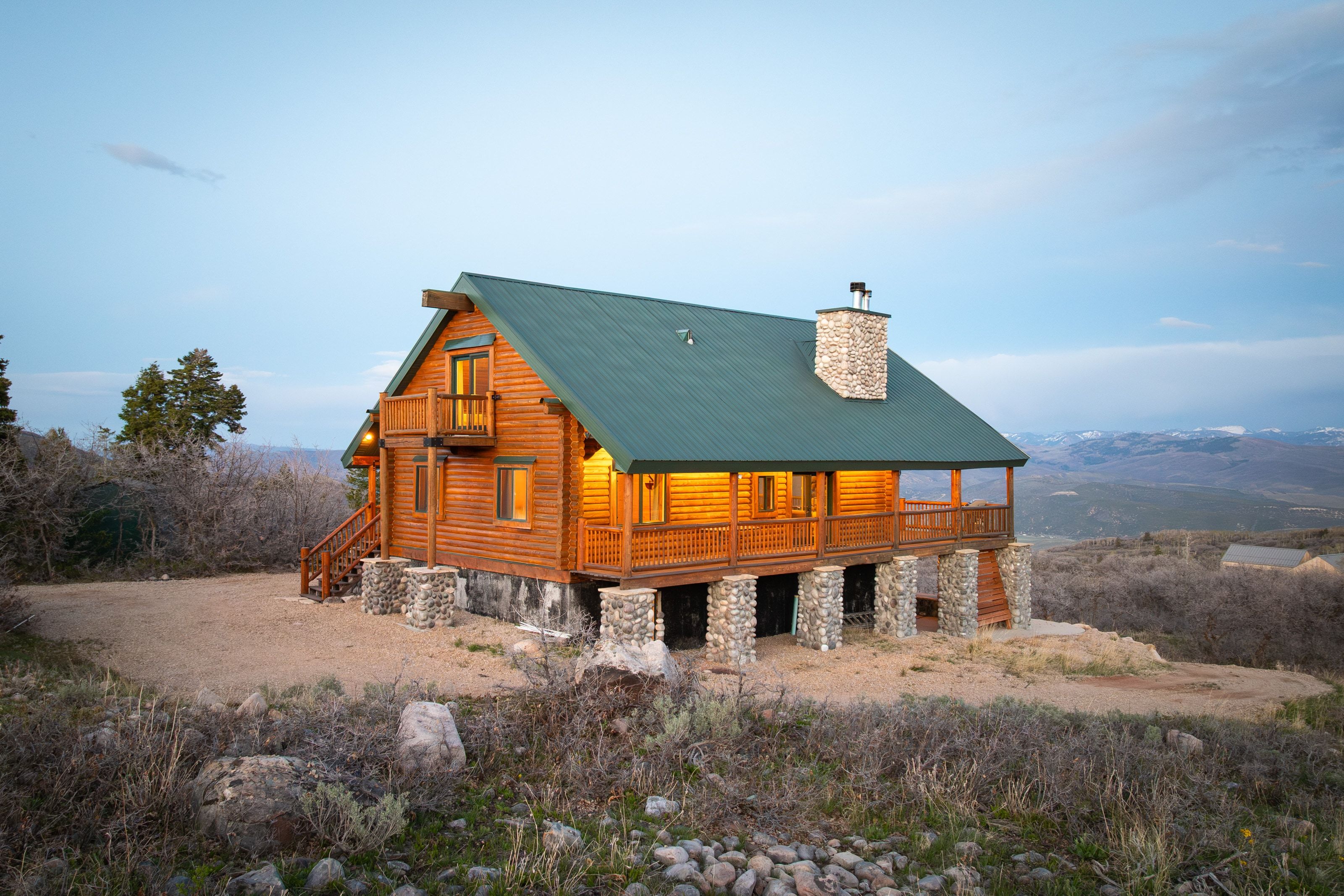 Back of house with a chimney, a metal roof, covered porch, and log exterior