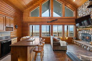 Living room with rustic walls, a vaulted wood ceiling, and a fireplace