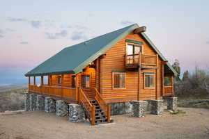 View of front of home with a metal roof, log exterior, and covered porch