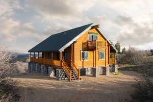 View of front of house with a porch and log siding