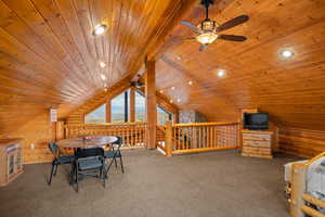 Carpeted bedroom featuring log walls, a wood ceiling with exposed beams, and access to outside
