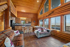 Living room with rustic walls and a vaulted wood ceiling