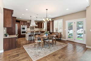 The kitchen features two-tone skyline cabinetry, upgraded granite countertops, subway tile backsplash, stainless steel appliances, double ovens, and a huge hidden pantry.