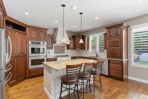 Upgraded granite countertops, stainless steel appliances, and a large island create a functional kitchen space that opens to gathering areas and a gas fireplace.
