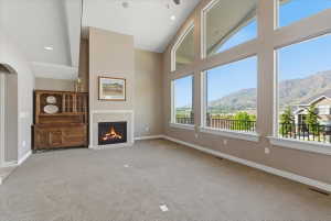 Living room featuring a gas fireplace, expansive windows, and mountain views, creating a bright gathering space filled with natural light.