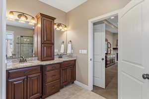 Double vanity with upgraded finishes provides ample space, with direct access to the primary suite.