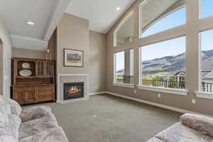 Living room featuring a gas fireplace, expansive windows, and mountain views, creating a bright gathering space filled with natural light.