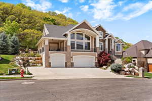 Wraparound covered front and back decks, a private backyard with a natural gas fireplace and waterfall feature, RV parking with electrical hookup, and a 4-car garage, all set on .65 acres with valley and mountain views.