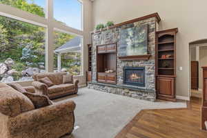 Expansive windows and a gas fireplace anchor this great room, creating a bright gathering space with natural light, mountain views, and engineered hardwood flooring.