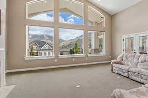 Living room with expansive windows that maximize natural light and showcase valley and mountain views, creating a bright and open gathering space.