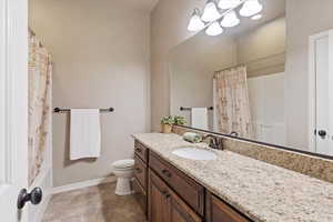 Bathroom with granite countertops and updated finishes, offering a clean and functional layout.