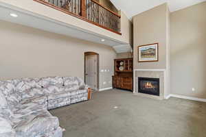 Living room with a gas fireplace and open layout connecting to upper-level spaces, creating a spacious gathering area.