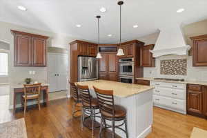 Large island with seating, double ovens, stainless steel appliances, and two-tone skyline cabinetry create a kitchen designed for gathering, with access to a huge hidden pantry.