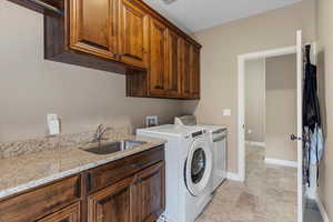 Main floor laundry and mudroom with a sink, abundant cabinetry, and upgraded finishes for added storage.
