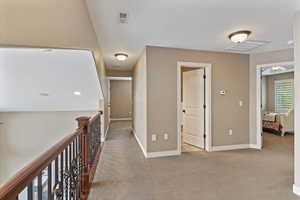 Second floor hallway with access to multiple bedrooms and open views to lower-level living spaces, enhancing the home’s layout and flow.