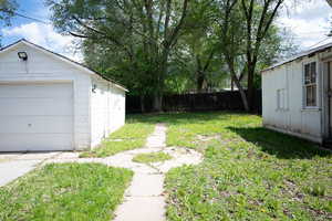 Fenced yard featuring an outbuilding and a detached garage