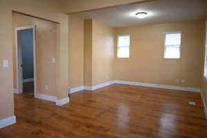 Empty room featuring dark wood-style floors and a textured ceiling